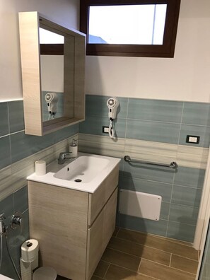 A bathroom with a sink, mirror, towel rack, and a window. - Playa Colorada (Gaeta)