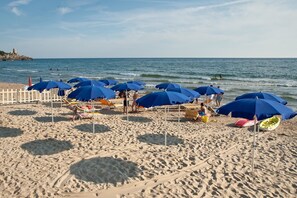 Playa privada, sillas reclinables de playa, sombrillas
