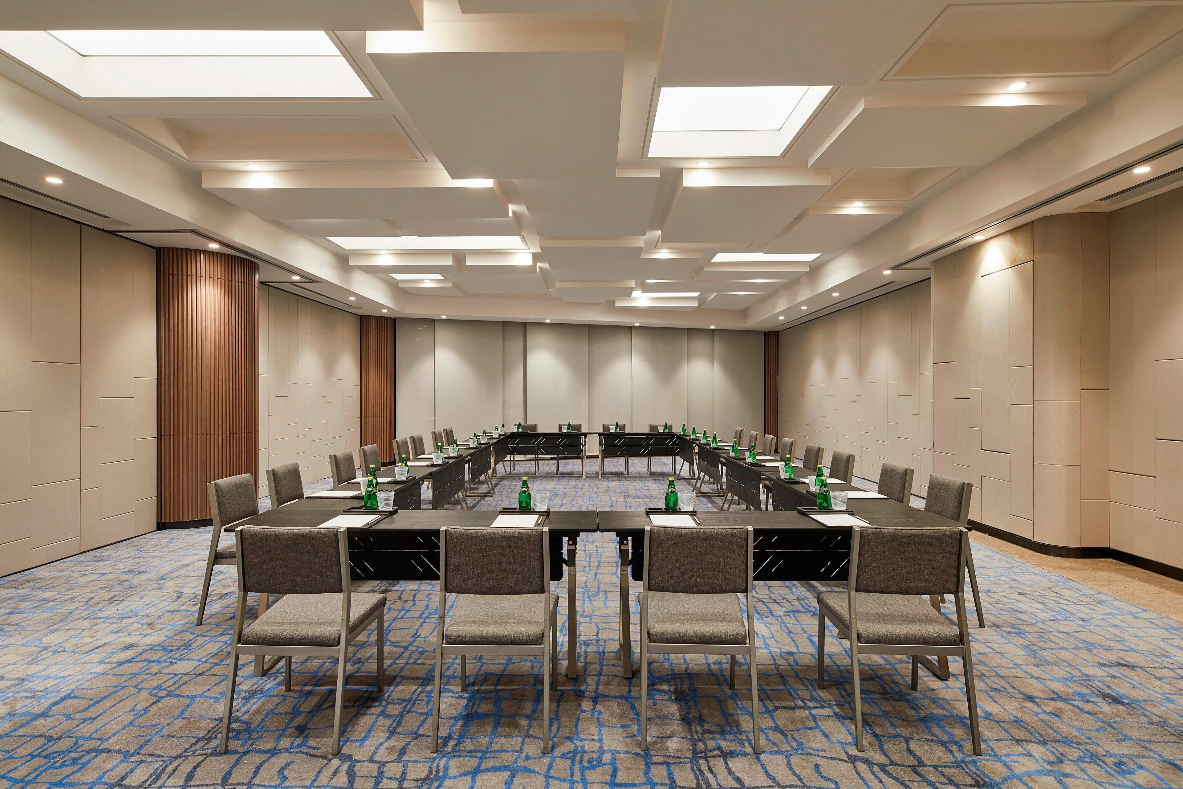 A conference room with a long table, chairs, and water bottles.