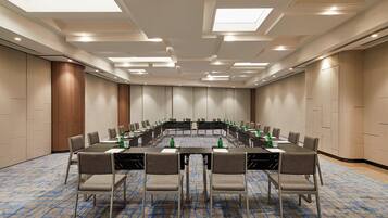 A conference room with a long table, chairs, and water bottles.