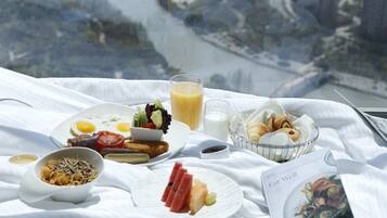 Un desayuno servido sobre un mantel blanco, con una vista panorámica a través de una ventana.