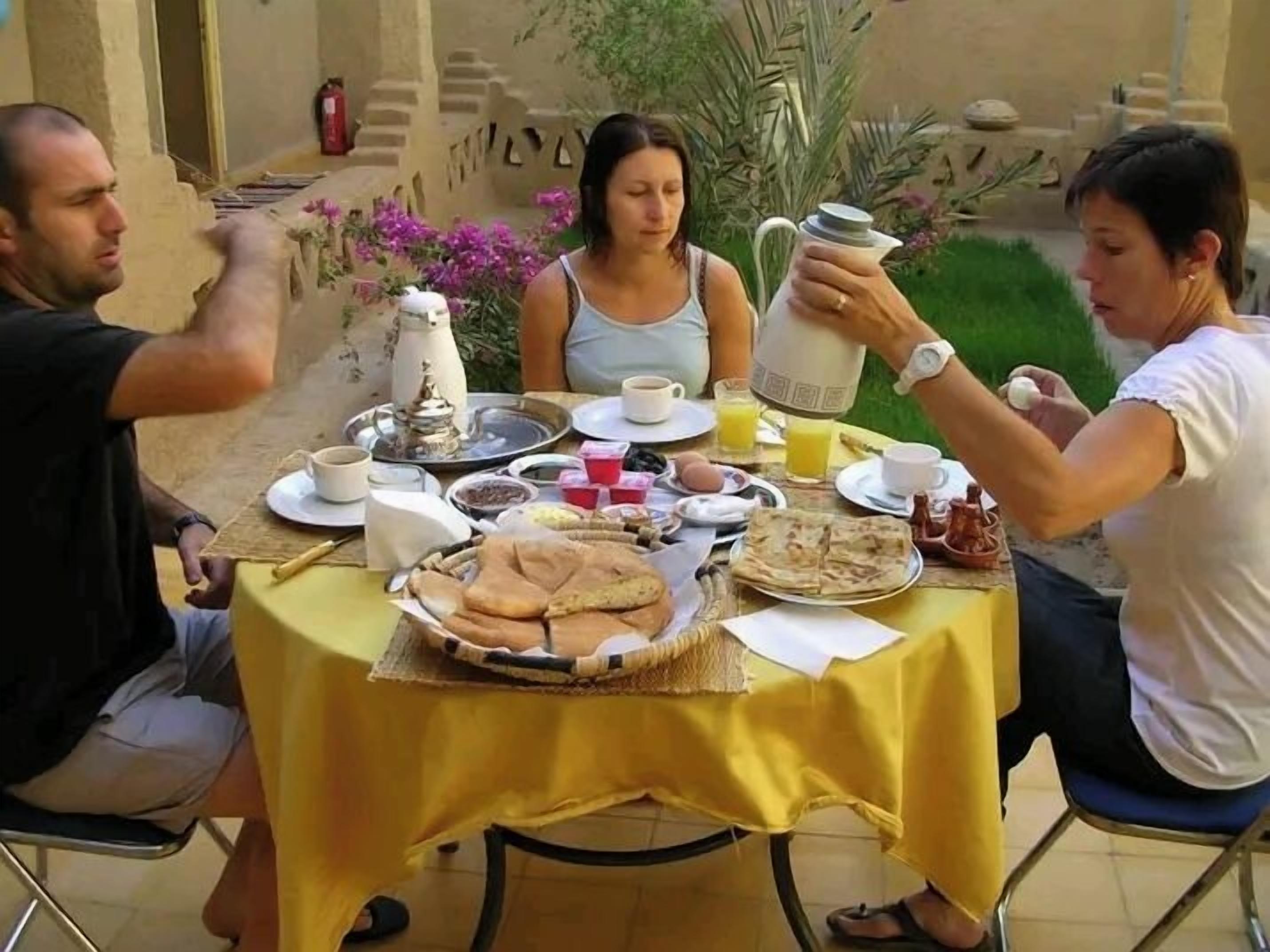 A table set for breakfast with various dishes, cups, and a pitcher.
