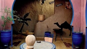 An outdoor patio with a fountain, seating area, and potted plants. - Riad Tadarte Merzouga Desert Tours (Taouz)