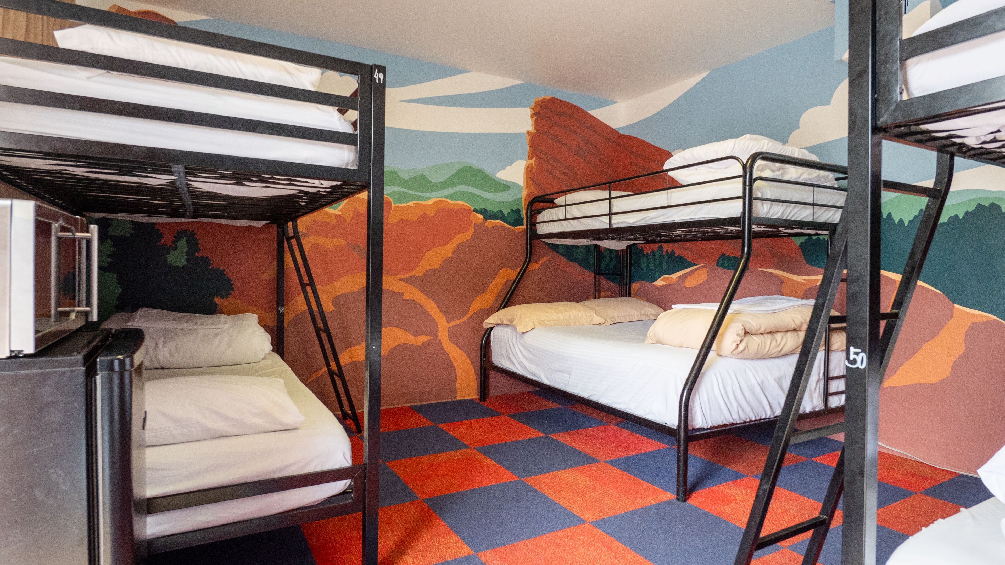 A bunk bed room with a checkered floor and a mural on the wall.