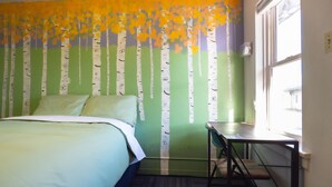 A bedroom with a bed, a desk, and a window. - RAD Hostel (Colorado Springs)