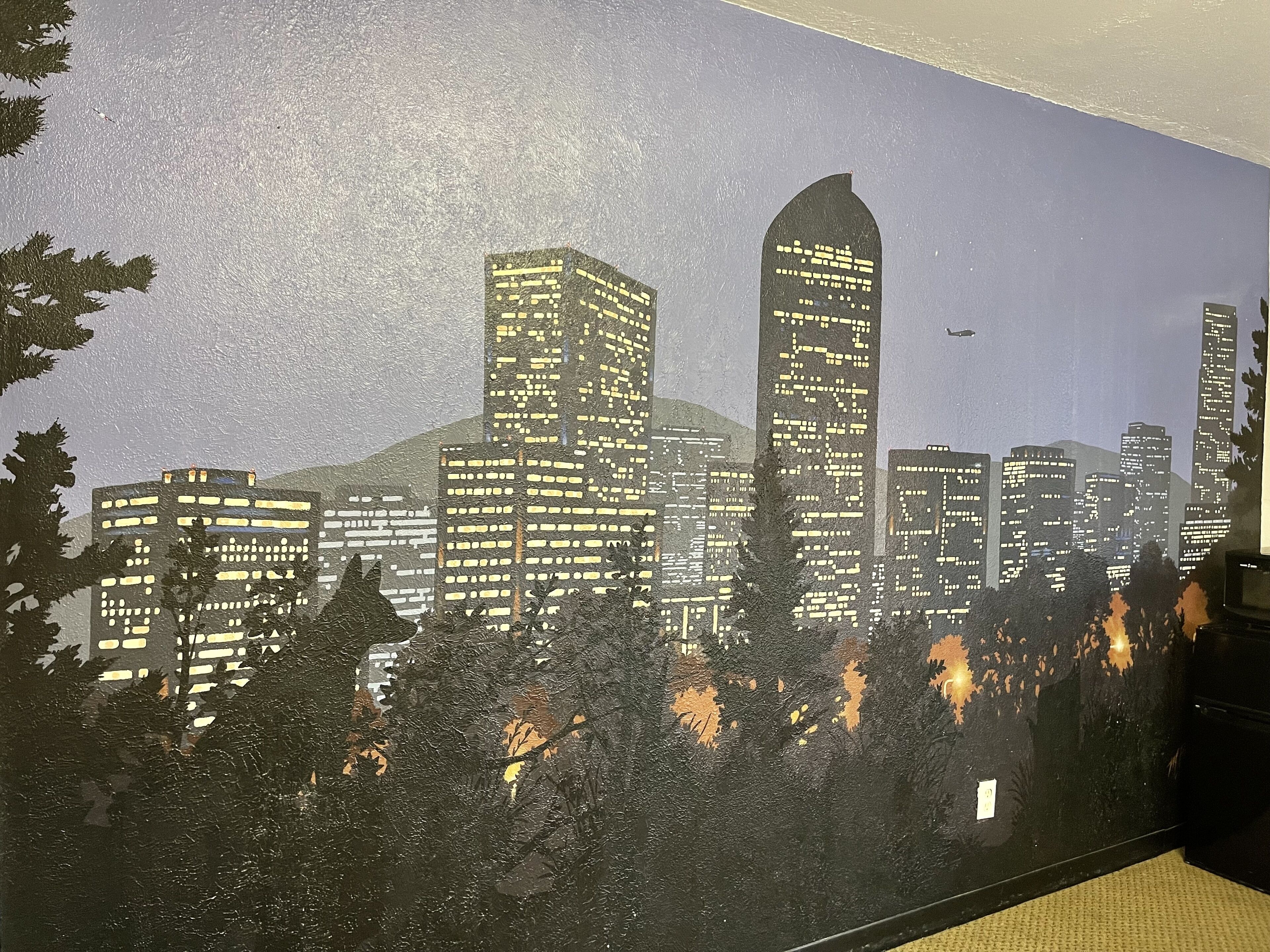 A cityscape mural with buildings and trees.