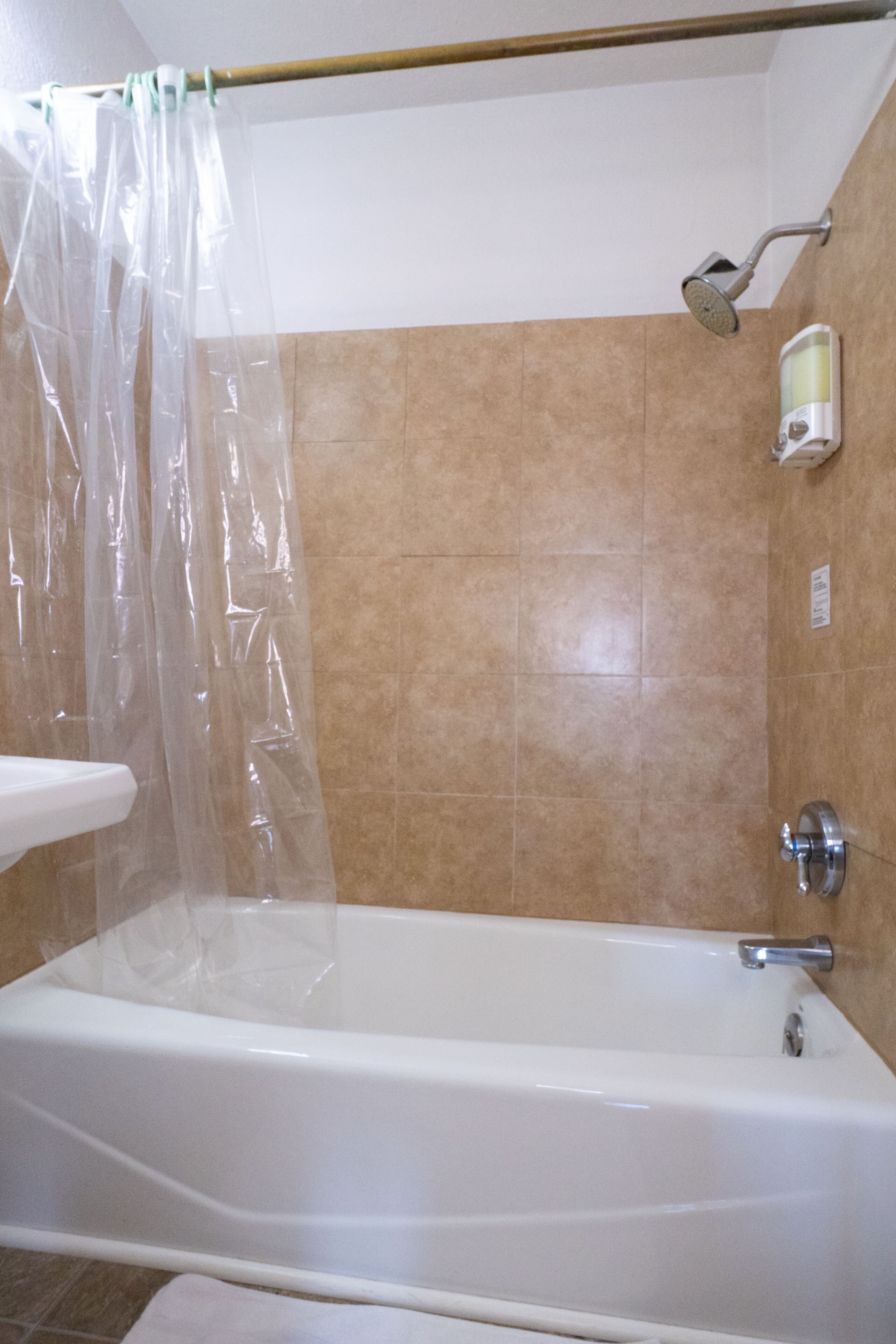 A bathroom with a bathtub, shower, and a towel rack.