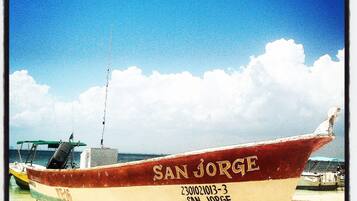 A boat named 'SAN JORGE' with the registration number '230102013-3' on a sandy beach.