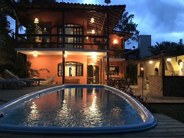 A two-story house with a swimming pool in the foreground.