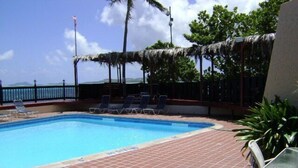 A rectangular pool with a tiled deck, surrounded by lounge chairs and a railing. - St Croix vacation rental (Christiansted)