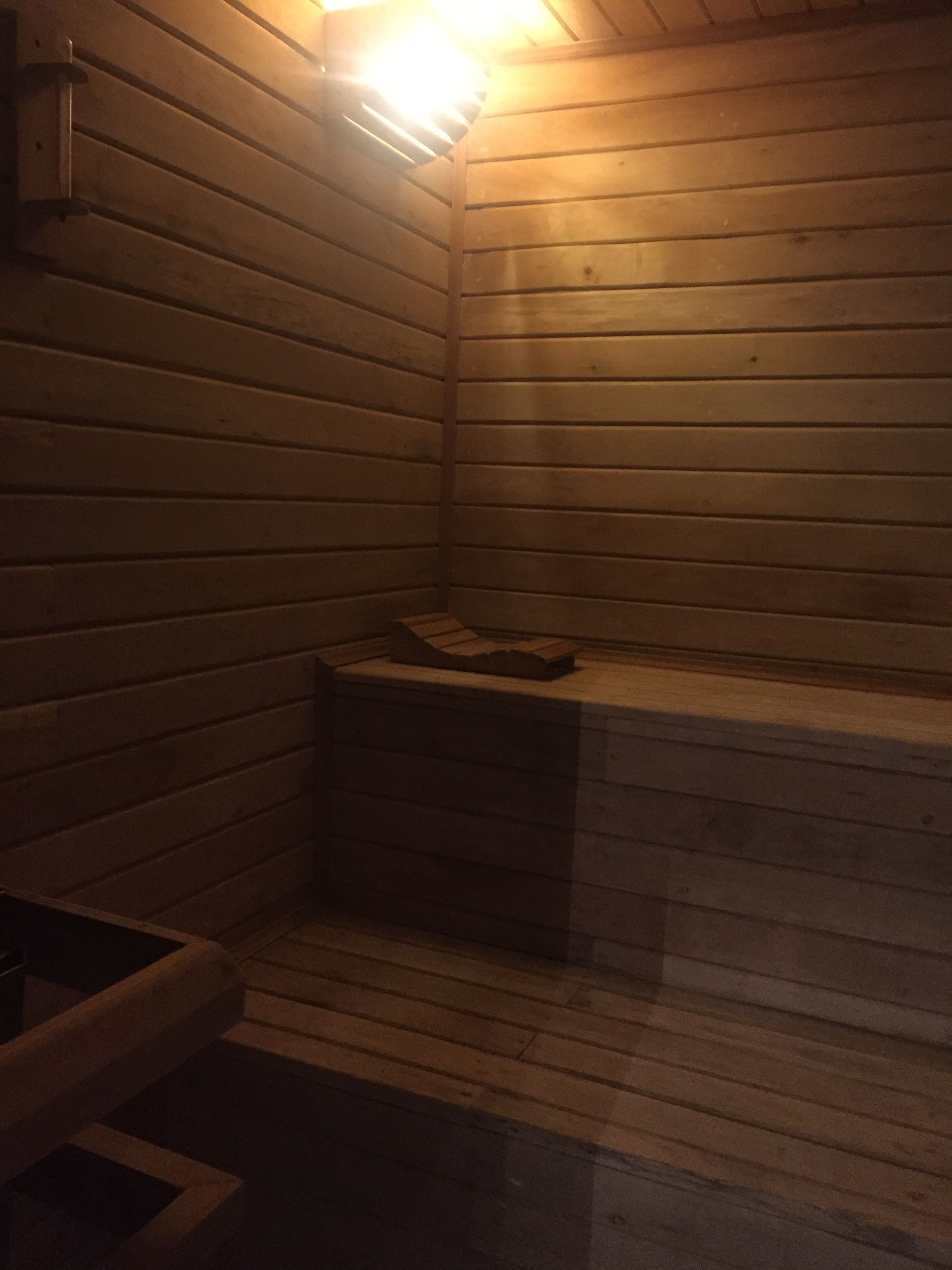 Eine Holzhüttensauna mit Bänken und einer Sitzbank.