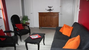 A living room with a dark grey sofa, two black armchairs, a small black coffee table, and a wooden cabinet with a decorative item on top. - Apartment TOU T CONFORT, in the HEART of Old Lille, Balconnet (Lille)