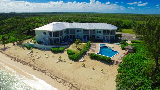 Un gran complejo turístico con varias construcciones, piscina y zona de playa con tumbonas.