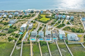 An aerial view of a coastal residential area with houses, a beach, and a golf course. - Experience beachside luxury at Oak Island's Marshy Marsh Funky Bunch, featuring 5 bedrooms. (Oak Island)