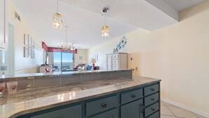 A kitchen with a marble countertop, blue cabinets, and pendant lights. - DIRECT GULF FRONT, AWESOME BEACHES, GREAT AMENITIES, ORANGE BEACH ACTIVITIES (Orange Beach)