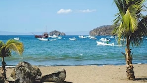 A beach with boats, palm trees, and a clear sky. - Stunning Ocean View from Luxury Two Bedroom in Pacifico  - Perfect Coco Location (Playa del Coco)