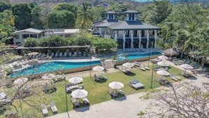 A resort with a pool, lounge chairs, and a view of the surrounding landscape. - Stunning Ocean View from Luxury Two Bedroom in Pacifico  - Perfect Coco Location (Playa del Coco)