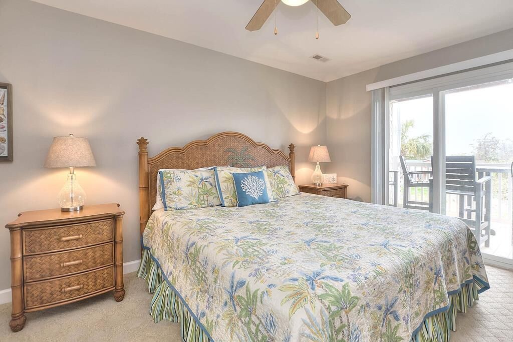 A bedroom with a bed, two bedside tables, and a large window.