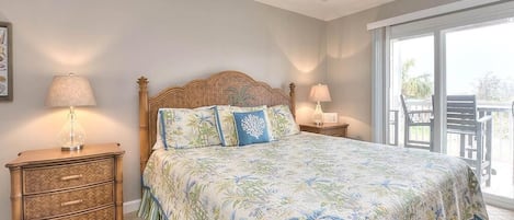A bedroom with a bed, two bedside tables, and a large window.