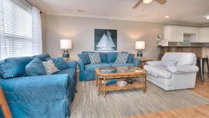 A living room with a sofa, armchairs, a coffee table, and a ceiling fan. - Oceanview retreat in Oak Island, 3BR condo with pool access and family amenities. (Oak Island)