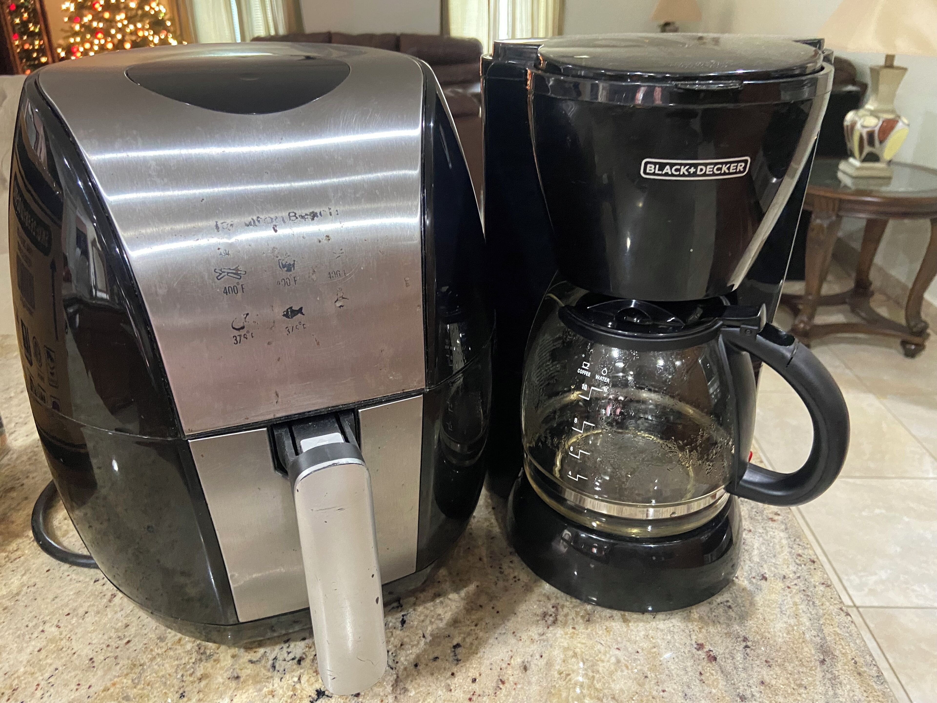 Een koffiezetapparaat met een opvangbak en een koffiekan op een aanrecht.