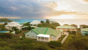 Um imóvel costeiro com várias casas, piscina e vista para o oceano.