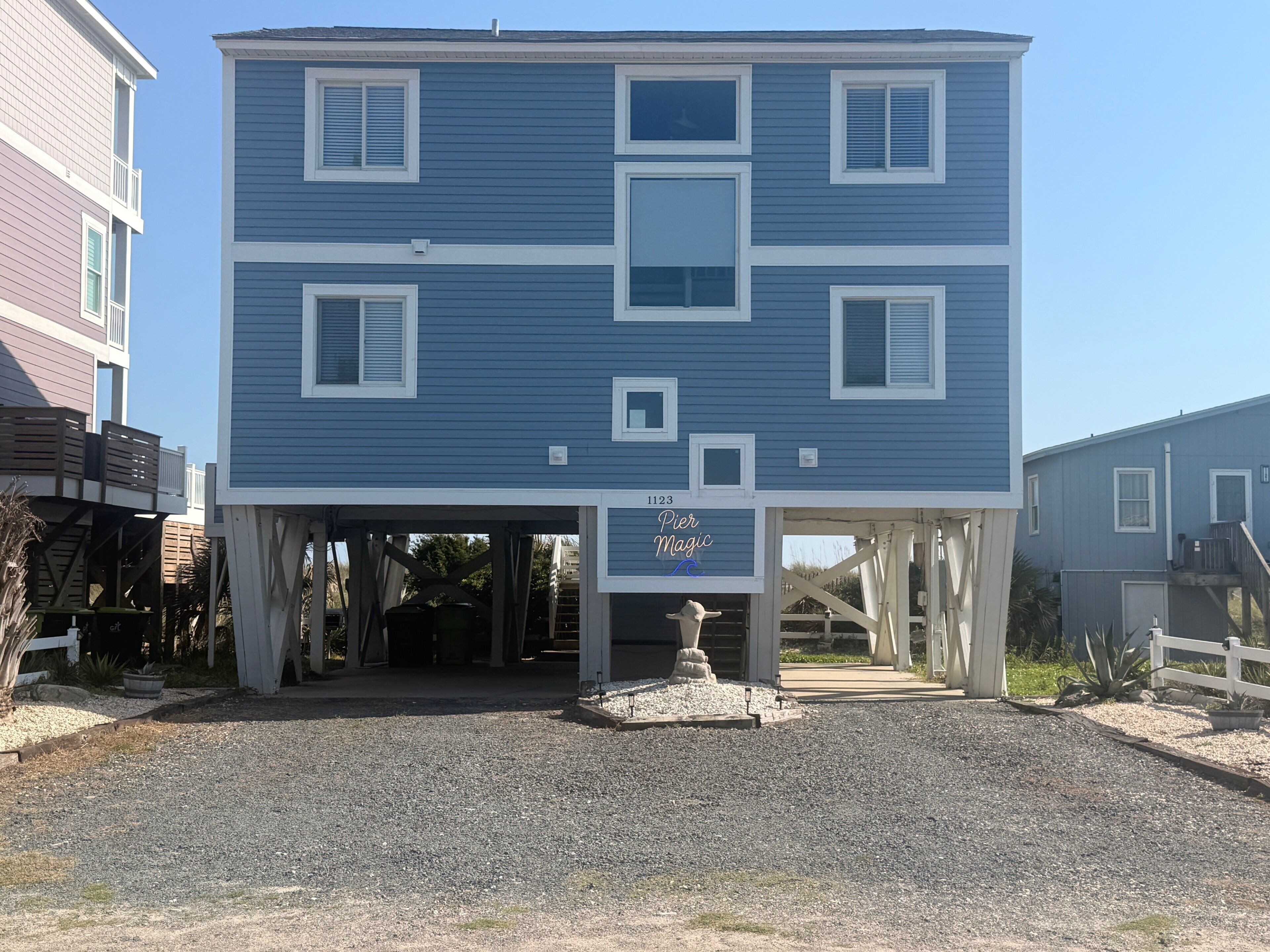 A two-story building with a covered entrance and a sign reading 'Pier Magic.'