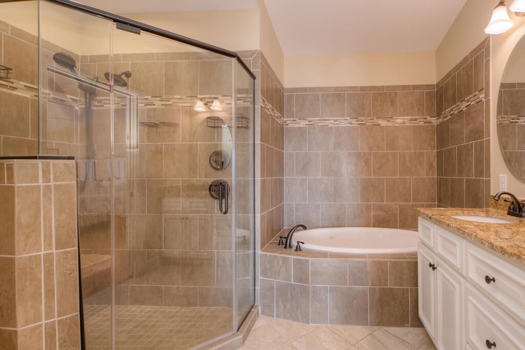 A modern bathroom with a glass-enclosed shower, a freestanding bathtub, and a vanity with a sink.