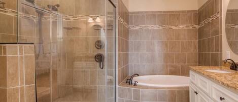 A modern bathroom with a glass-enclosed shower, a freestanding bathtub, and a vanity with a sink.