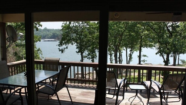 A wooden deck with a glass door, overlooking a lake with trees. - Have it All!!! True Water Front, Amazing Views (Golden)