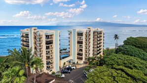 Un hotel moderno con múltiples balcones que dan a una playa y al océano.