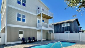 Un bâtiment à deux étages doté d’un balcon, d’une piscine et d’une terrasse en briques.