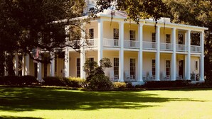 A large, two-story building with a symmetrical facade, multiple balconies, and a well-maintained lawn. - Hidden Beach Hideaway — 200 Yards to Sand, Free Bikes, Pool & WiFi (Seagrove Beach)