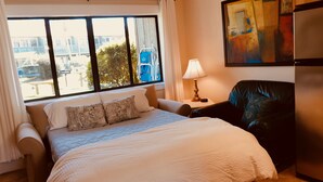 A hotel room with a large bed, a chair, a lamp, and a painting on the wall. - Hidden Beach Hideaway — 200 Yards to Sand, Free Bikes, Pool & WiFi (Seagrove Beach)