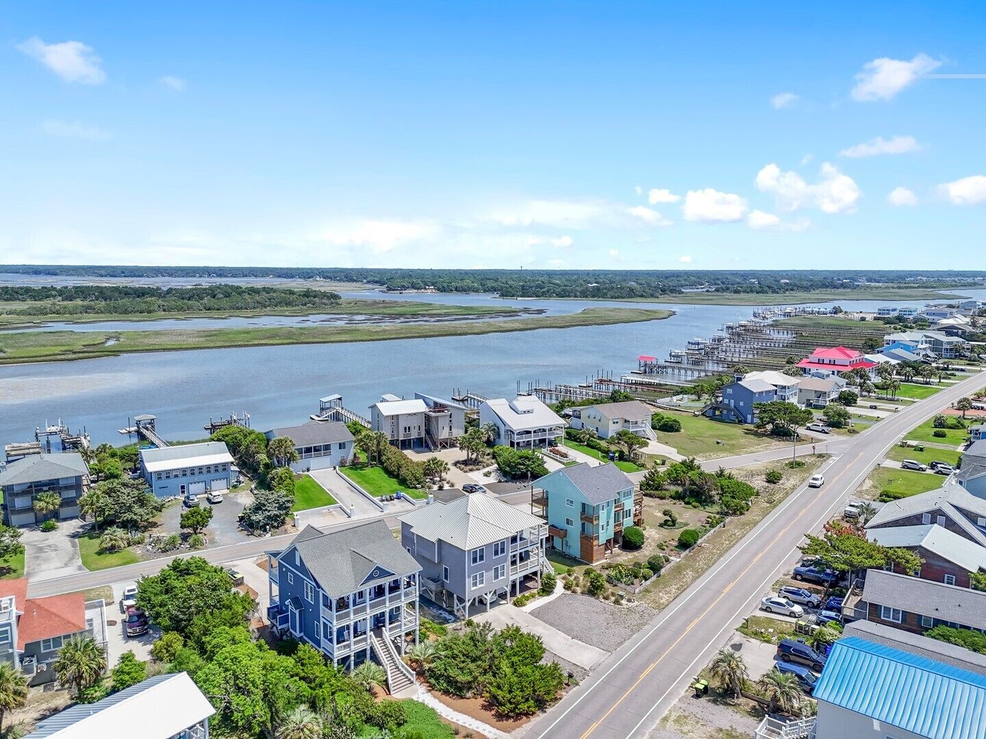 Une zone résidentielle côtière comprenant des maisons, un port de plaisance et une vaste étendue d’eau.