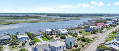 Une zone résidentielle côtière comprenant des maisons, un port de plaisance et une vaste étendue d’eau.
