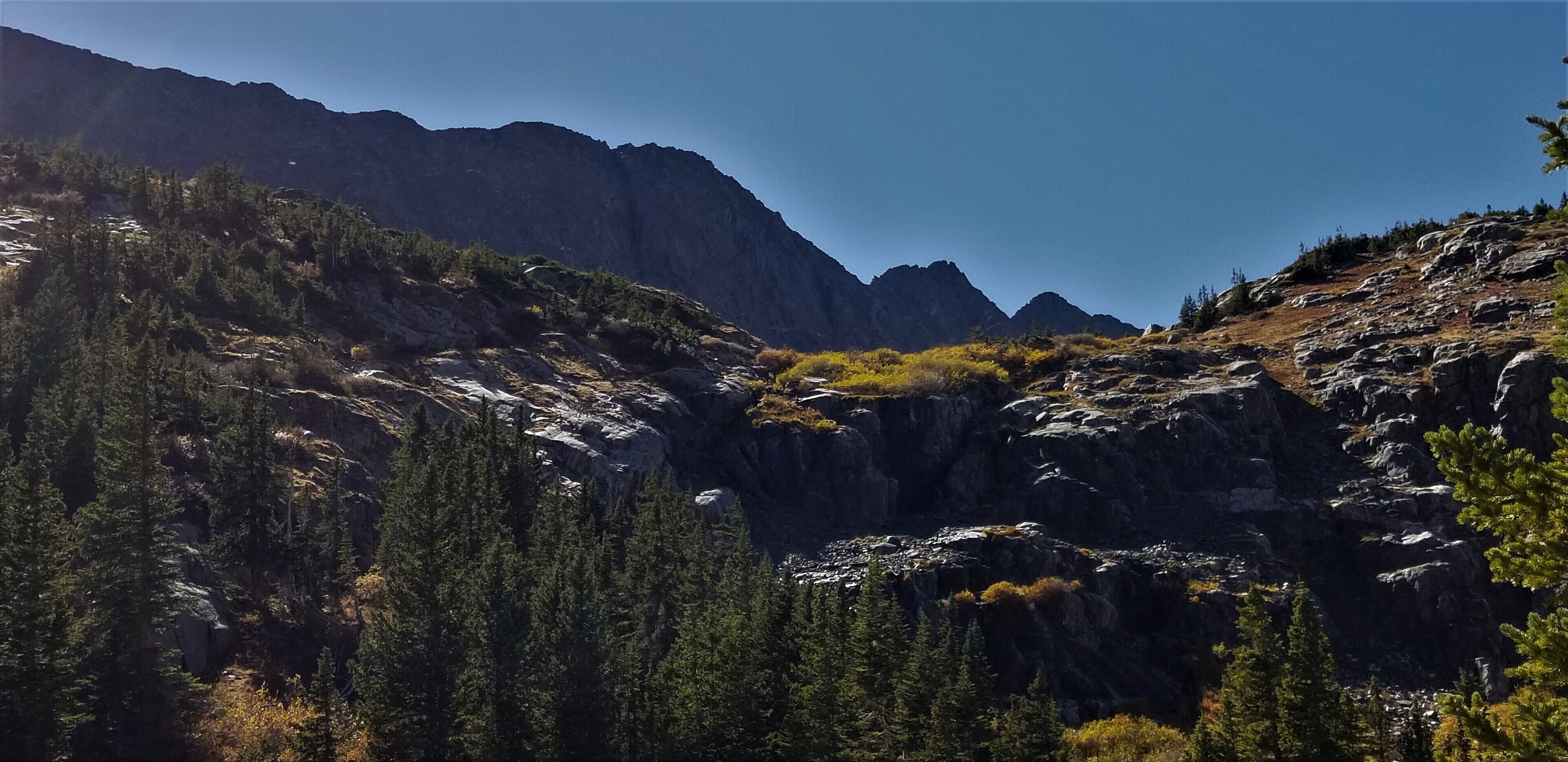 Un paysage montagneux caractérisé par de vastes forêts et un terrain rocheux.