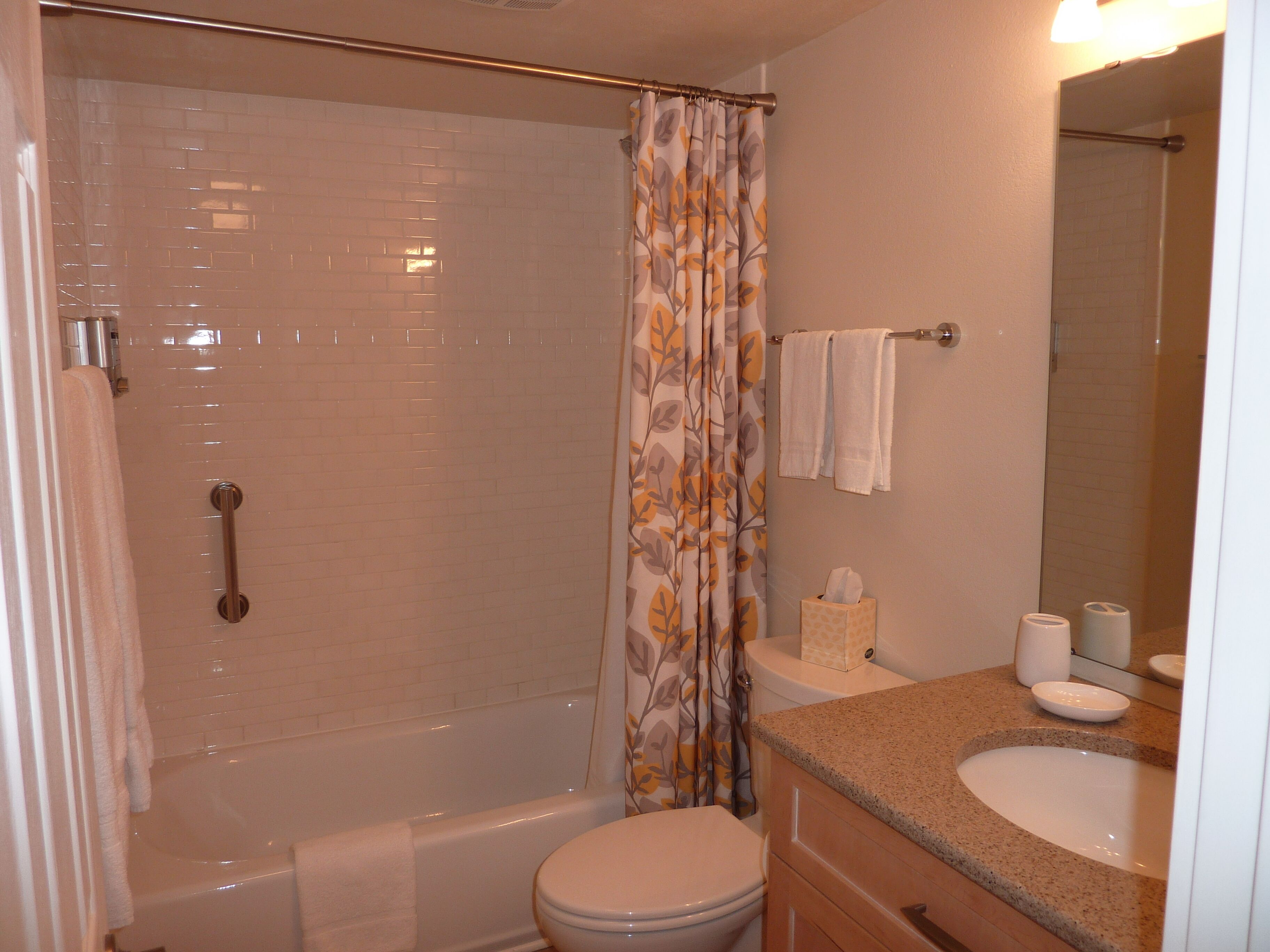 A bathroom with a shower, toilet, and sink.