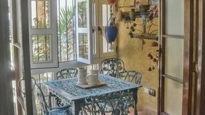 Un comedor con una mesa y sillas, una lámpara colgante y vistas por una ventana.