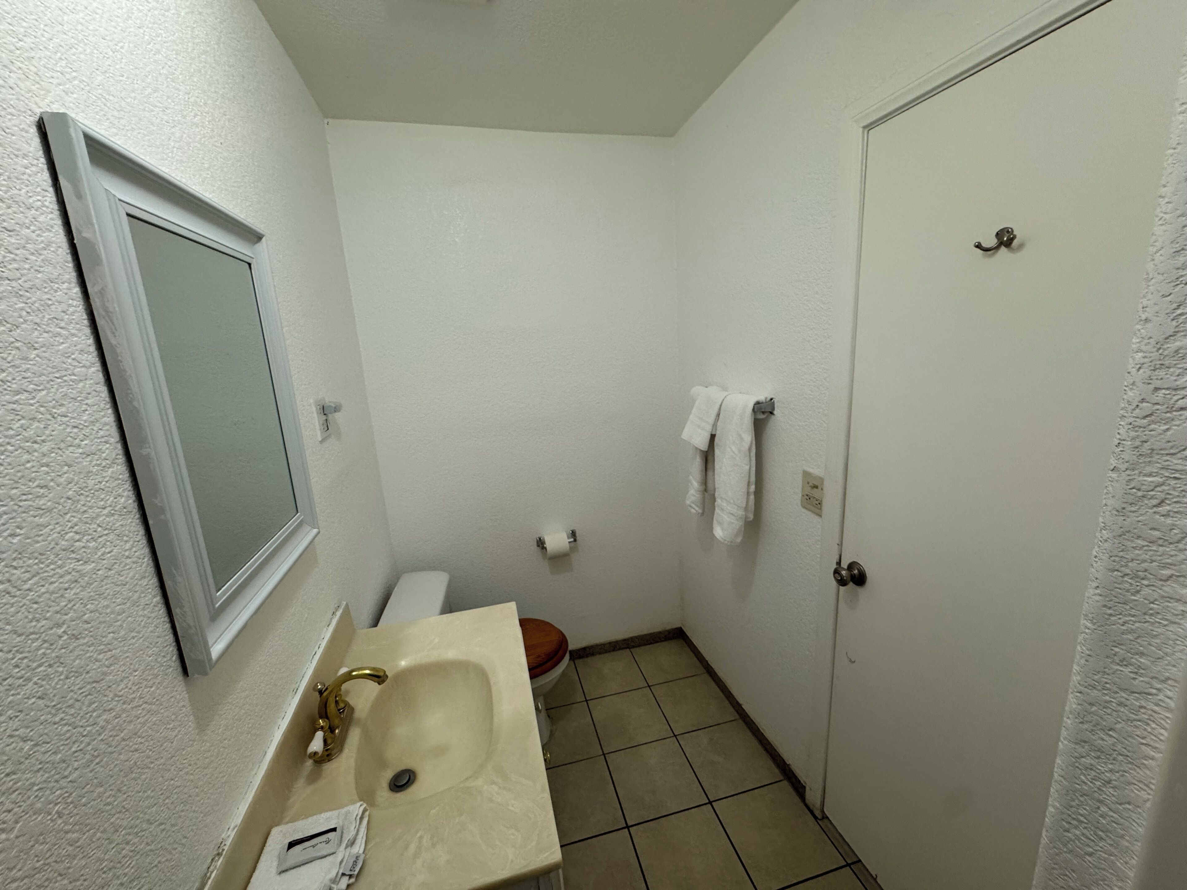 Un bagno piccolo e pulito, con lavandino, wc e specchio.