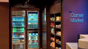 A corner market with refrigerated beverage dispensers and shelves stocked with snacks and groceries. - Fairfield Inn & Suites by Marriott Buffalo Amherst/University (Buffalo)