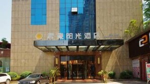 A hotel entrance with a modern design, featuring a glass facade and a prominent entrance with a canopy. - Jun Hao Sunshine Hotel (Suining)