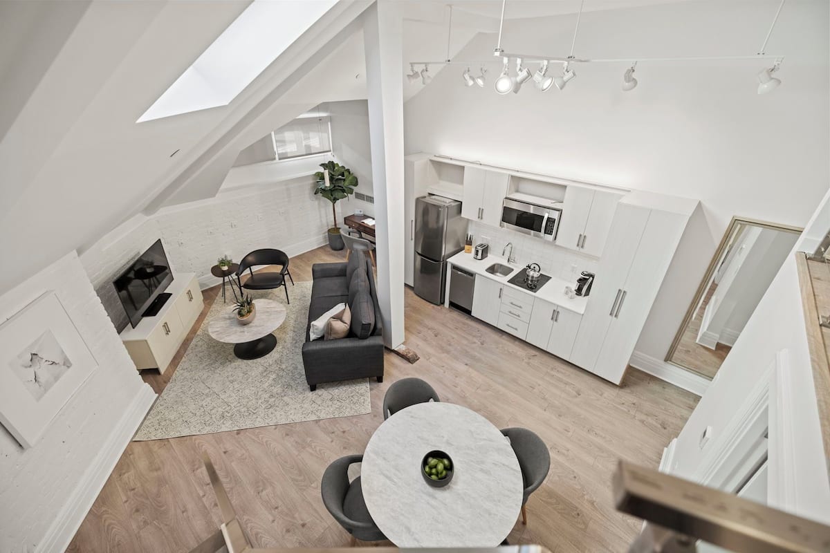 A modern loft-style apartment with a kitchen, dining area, and living space.