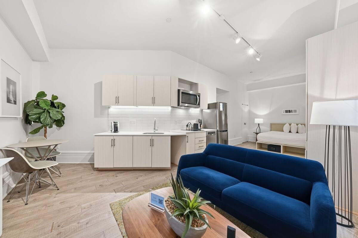 A modern apartment with a kitchen, dining area, and living room.
