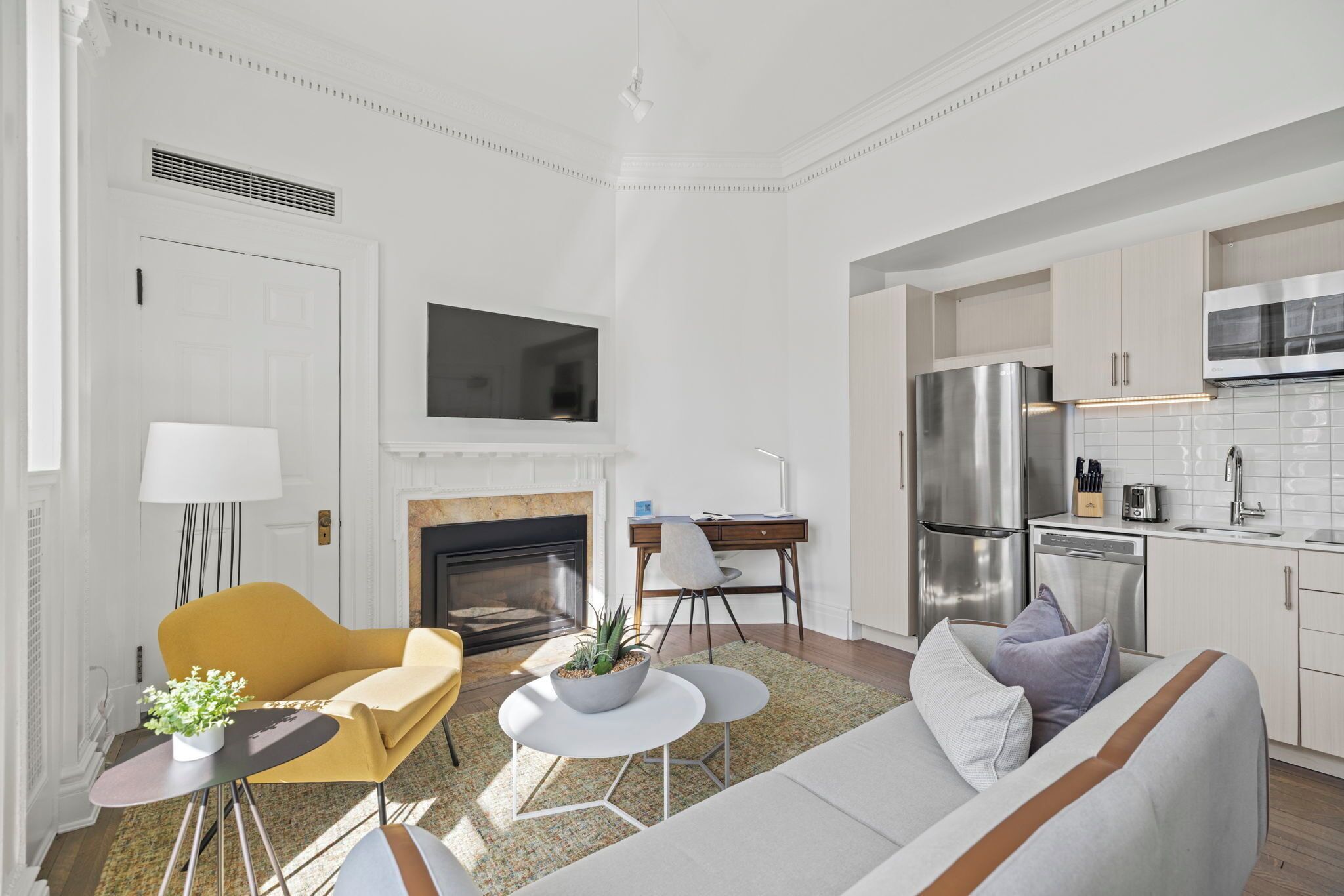 Un salon moderne avec un canapé, un fauteuil, une table basse et une cheminée.