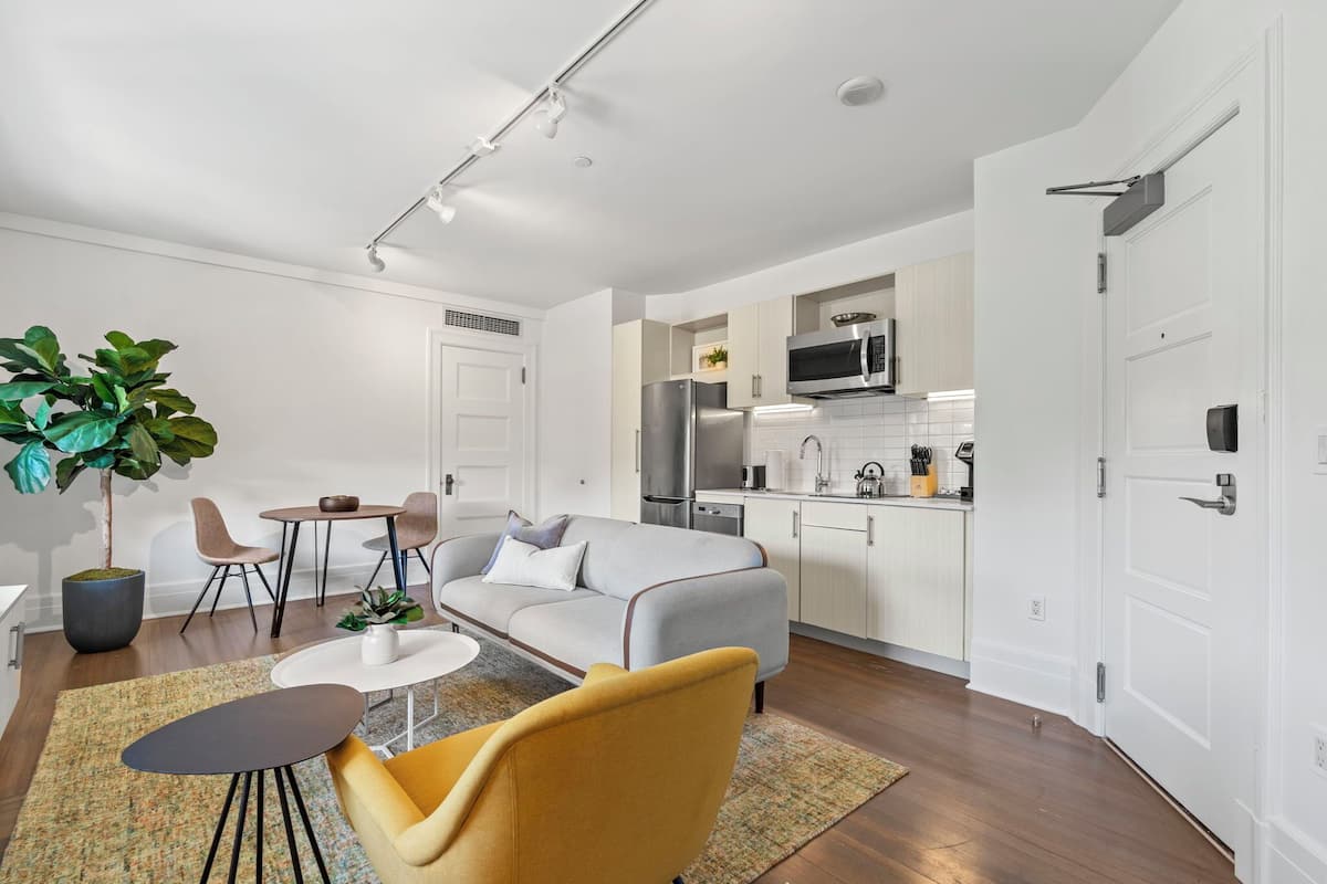 A modern apartment with a living room, dining area, and kitchen.