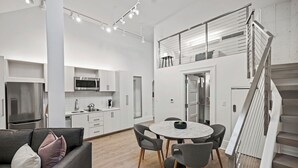 A modern apartment with a kitchen, dining area, and a staircase. - Placemakr Dupont Circle (Washington)