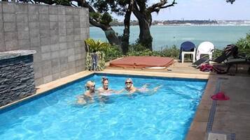 Una piscina al aire libre, sillones reclinables de piscina