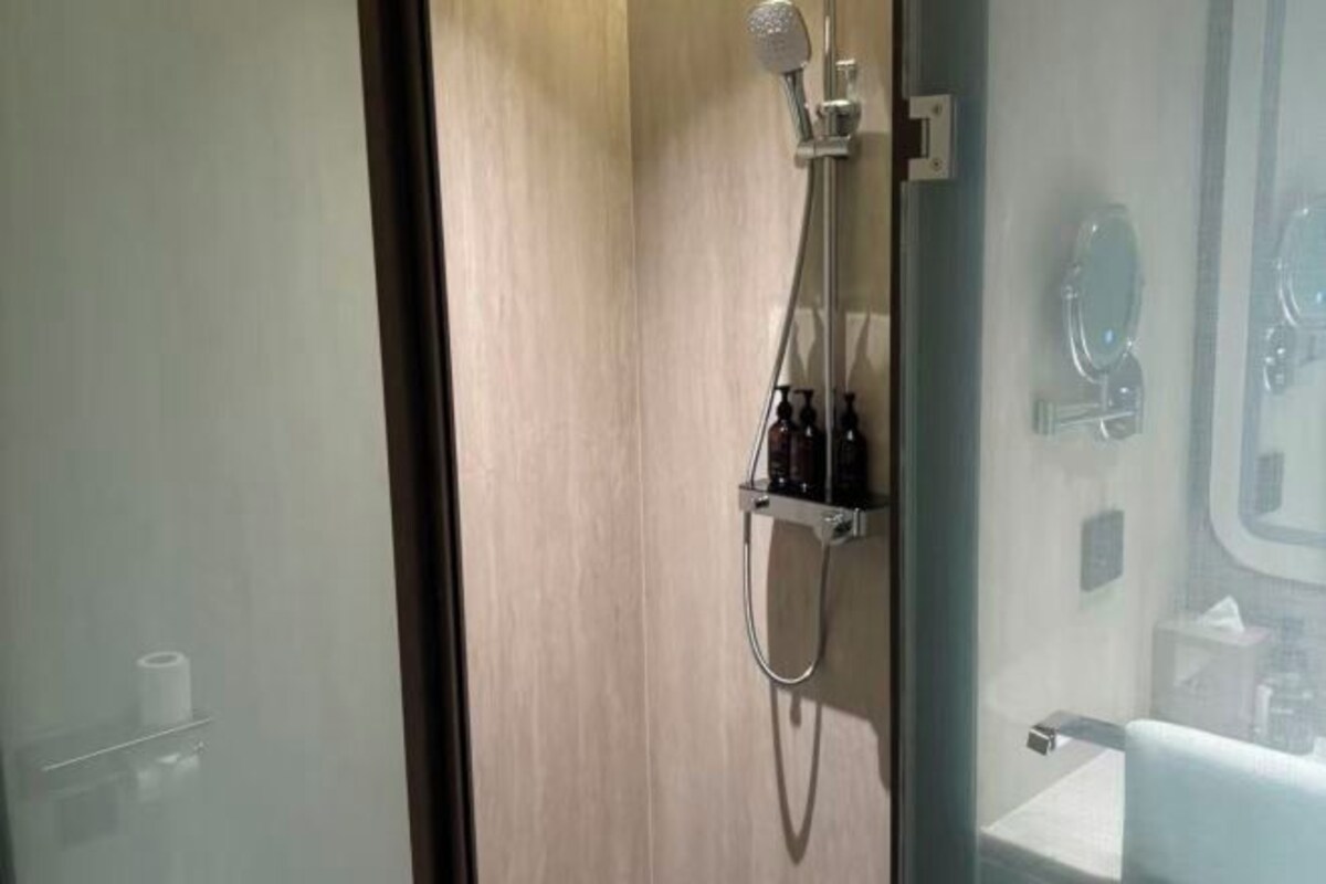 Un baño moderno con cabina de ducha de vidrio, un inodoro y un lavabo.