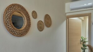 A wall with a large woven mirror and three smaller woven wall hangings. - "Ilios" apartment - 1 Bedroom Apt / Sea view /Shared Pool / Sleeps 4 (Malevizi)